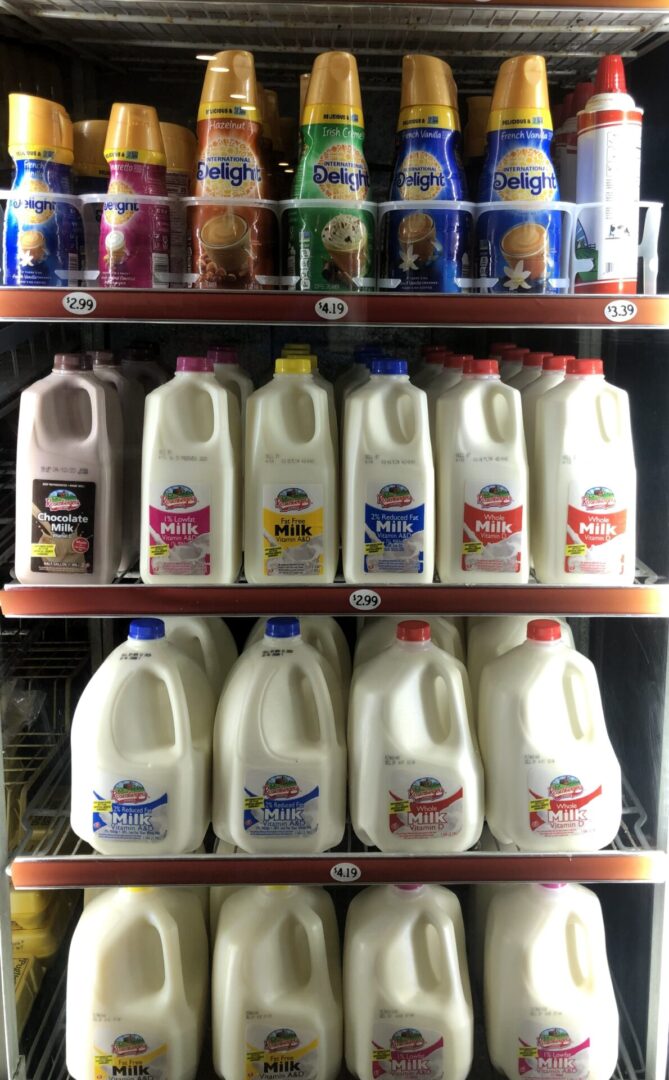 A shelf with milk and other dairy products.